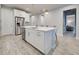 Bright kitchen with a large island, stainless steel appliances, pendant lighting, and white cabinets at 11842 Sistine Ln, Venice, FL 34293