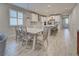 Bright open-concept kitchen featuring white cabinets, stainless steel appliances, and a large center island with bar seating at 11842 Sistine Ln, Venice, FL 34293