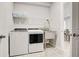 Laundry room with stainless steel sink and storage shelves above washer and dryer at 11842 Sistine Ln, Venice, FL 34293