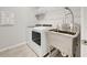 Laundry room with stainless steel sink and storage shelves above washer and dryer at 11842 Sistine Ln, Venice, FL 34293