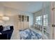 Office with natural light, work desk and shelving with a comfy dark sofa and accent rug at 11842 Sistine Ln, Venice, FL 34293
