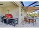 Covered patio featuring a pizza oven, barbecue, and an outdoor dining area at 11842 Sistine Ln, Venice, FL 34293