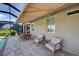 Covered outdoor patio offers dining and seating with an awning for shade and backyard views at 11842 Sistine Ln, Venice, FL 34293