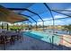 Inviting screened pool features a seating area and a beautiful view of the adjacent waterway at 11842 Sistine Ln, Venice, FL 34293