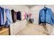 Walk-in closet with a large wardrobe, shelving for storage and carpeted floors at 11842 Sistine Ln, Venice, FL 34293