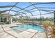 Inviting pool and spa with screened enclosure, patio, and lake view at 12353 Auburndale Ct, Venice, FL 34293