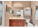 Clean bathroom with wood vanity, toilet and linen cabinet at 13542 Abercrombie Dr, Englewood, FL 34223