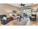 Relaxing living room with a comfy sofa, two armchairs and sliding glass door at 13542 Abercrombie Dr, Englewood, FL 34223
