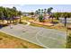 Outdoor area with a basketball court, playground, and ample parking surrounded by mature trees at 14098 Baracoa Ln, Port Charlotte, FL 33981
