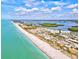 Expansive aerial view of a beach with clear blue water and a vibrant coastal community at 14098 Baracoa Ln, Port Charlotte, FL 33981