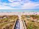 Scenic beach access with wooden steps leading to a sandy beach and serene ocean views at 14098 Baracoa Ln, Port Charlotte, FL 33981