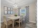 Charming dining room with a white table, four chairs, and patterned curtains at 14098 Baracoa Ln, Port Charlotte, FL 33981