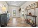 Bright and airy entryway with stylish wood-look flooring, an accent console, and a transom window at 14098 Baracoa Ln, Port Charlotte, FL 33981