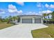 3-car garage, light green house with palm trees at 14098 Baracoa Ln, Port Charlotte, FL 33981