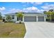 Charming single-story home featuring a three-car garage and a well-maintained front yard, perfect for curb appeal at 14098 Baracoa Ln, Port Charlotte, FL 33981