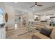 Open-concept living room with tray ceilings, wood-look tile, comfortable seating, and natural light at 14098 Baracoa Ln, Port Charlotte, FL 33981
