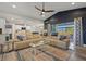 Open-concept living room with leather sofas, ceiling fan, and decorative oars on the accent wall at 14098 Baracoa Ln, Port Charlotte, FL 33981
