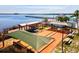 Overhead view of a recreation area with bocce ball courts, benches, and a pier extending into the bay at 14098 Baracoa Ln, Port Charlotte, FL 33981