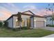 One-story home with gray siding and a two-car garage, nicely landscaped at 14454 Little Eagle Loop, Nokomis, FL 34275