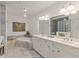 Elegant bathroom with double vanity, soaking tub, and glass block shower at 157 Tampa E Ave # 208, Venice, FL 34285