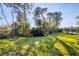Landscaped backyard with mature trees and pond views at 1584 Monarch Dr, Venice, FL 34293