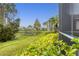 Backyard with pond view, lush landscaping, and screened patio at 1584 Monarch Dr, Venice, FL 34293