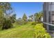 Spacious backyard with pond view, lush landscaping, and screened patio at 1584 Monarch Dr, Venice, FL 34293