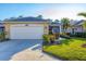 House exterior showcasing a white garage door and lush landscaping at 1584 Monarch Dr, Venice, FL 34293