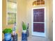 Elegant front door entry with a screen door and potted plants at 1584 Monarch Dr, Venice, FL 34293