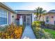 Welcoming front entrance with a screened porch and colorful landscaping at 1584 Monarch Dr, Venice, FL 34293