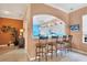 Kitchen breakfast bar with three stools, view into main living area at 1584 Monarch Dr, Venice, FL 34293