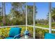 Enjoy the view from this screened porch with teal seating at 1584 Monarch Dr, Venice, FL 34293