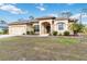 Tan one-story house with a two-car garage and manicured lawn at 1684 Ruiz St, North Port, FL 34286