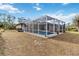 Enclosed rectangular pool with patio furniture and lush greenery at 1684 Ruiz St, North Port, FL 34286