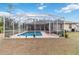 Screened-in rectangular pool with lounge chairs in the backyard at 1684 Ruiz St, North Port, FL 34286