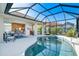 Spacious lanai with a pool, covered seating, and dining area, seamlessly blending indoor and outdoor living at 1721 Dogleg Dr, Venice, FL 34285