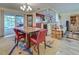 Bright dining room features a wood table, red chairs, and a view of the pool at 1723 N Gondola Ct, Venice, FL 34293
