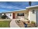 Inviting front porch with seating area, landscaping, and a red door at 1723 N Gondola Ct, Venice, FL 34293