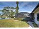 Screened pool and patio area with lush landscaping overlooking a tranquil lake at 1723 N Gondola Ct, Venice, FL 34293