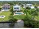 Aerial view of a home with a pool, landscaped yard, and waterfront access at 1784 Bayshore Dr, Englewood, FL 34223