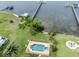 Aerial view of waterfront property showcasing the pool, landscaping and dock at 1784 Bayshore Dr, Englewood, FL 34223