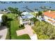 Waterfront property features lush landscaping, a dock, and a charming yellow exterior at 1784 Bayshore Dr, Englewood, FL 34223