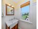 Charming bathroom with a pedestal sink and a view of the backyard at 1784 Bayshore Dr, Englewood, FL 34223