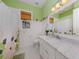 Bright bathroom with a window, toilet, and vanity featuring a marble countertop at 1784 Bayshore Dr, Englewood, FL 34223