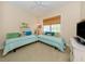 Comfortable bedroom featuring two twin beds, a ceiling fan, and a window with natural light at 1784 Bayshore Dr, Englewood, FL 34223