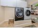 Practical laundry room with modern appliances, storage cabinets, and shelving at 1784 Bayshore Dr, Englewood, FL 34223