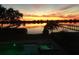 Waterfront view with pool and spa, capturing a golden sunset sky at 1784 Bayshore Dr, Englewood, FL 34223