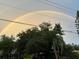 Stunning double rainbow arcs across the sky, framed by lush green trees and foliage at 1784 Bayshore Dr, Englewood, FL 34223