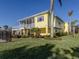 Beautiful yellow home with a screened porch, white railings, and lush landscaping at 1784 Bayshore Dr, Englewood, FL 34223