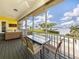 Screened porch with outdoor dining set and seating, offering waterfront views at 1784 Bayshore Dr, Englewood, FL 34223